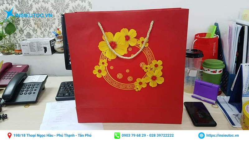 Túi giấy có tone đỏ chủ đạo kết hợp với họa tiết mai vàng