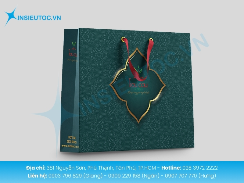 Túi giấy xanh dập họa tiết sang trọng, dây ruy băng đỏ thương hiệu Trầu Cau