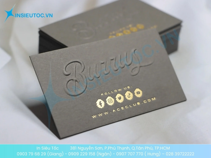 Name card xám ép kim vàng nổi, logo chữ viết Buttuso và icon mạng xã hội cao cấp